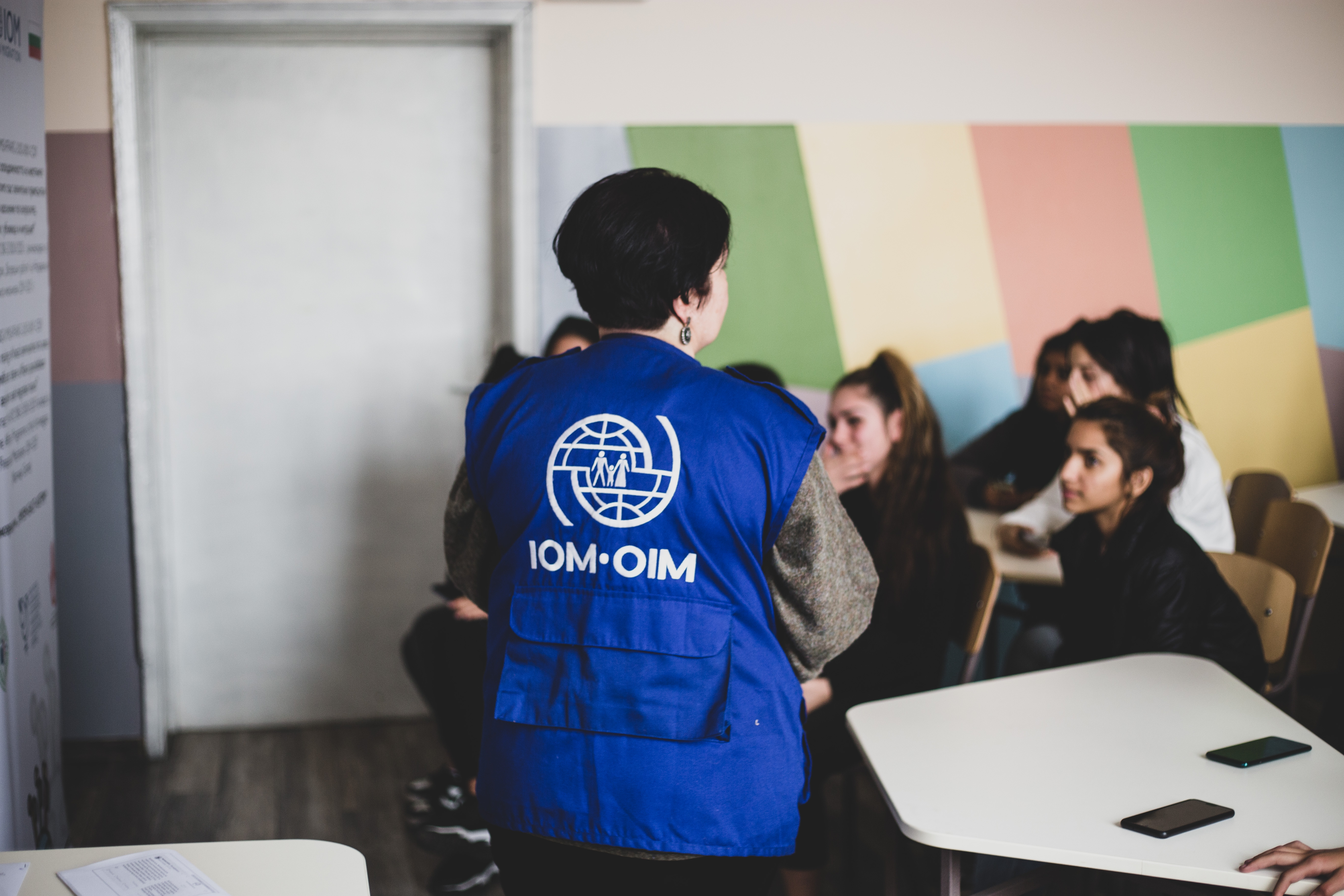 IOM team member in front of a school audience